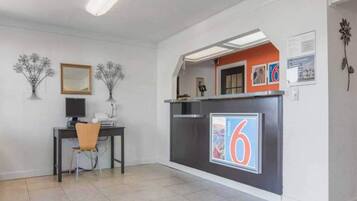 A reception area with a desk, chair, and a large number '6' sign.