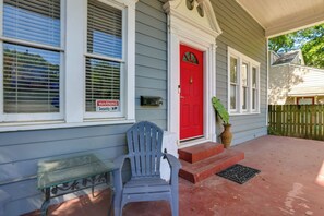 A house with a red door, a mailbox, a bench, and a potted plant on the porch. - Quaint North Campus Bungalow Minutes From Downtown (Austin)