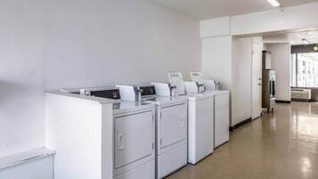 A laundry facility with multiple washing machines and dryers.