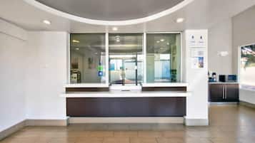 A reception area with a curved ceiling, a counter, and a view of the interior through glass doors.