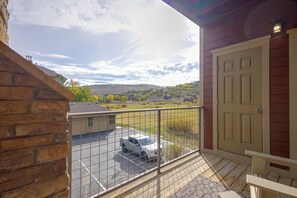 Ein Balkon mit Blick auf einen Parkplatz und eine entfernte Landschaft.