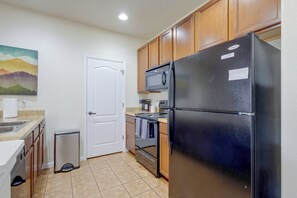A compact kitchen with a refrigerator, stove, microwave, and a trash bin. - Ski Granby Ranch! Condo w/ Community Hot Tub (Granby)