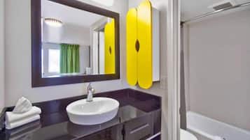Une salle de bain avec un lavabo rond, un miroir et des toilettes.