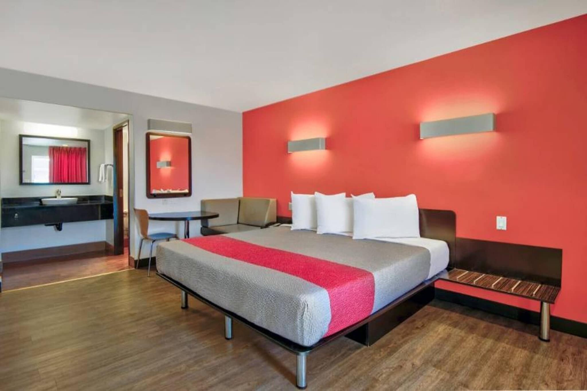 A hotel room with a bed, a desk, and a chair.