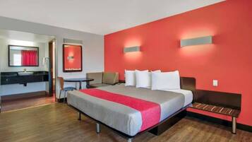 A hotel room with a bed, a desk, and a chair.