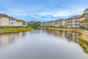 A residential area with a calm water body, likely a canal, surrounded by apartment buildings with balconies. - Walk to Ocean & Eats! Lake-View Myrtle Beach Haven (North Myrtle Beach)