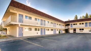 A motel with a central courtyard, multiple balconies, and a parking lot.