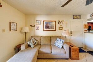 A living room with a sofa, a lamp, a small table, and a wall with framed pictures. - Work + Relax Poolside! Nurse-Ready Glendale Rental (Glendale)