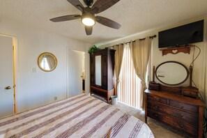 A bedroom with a bed, a dresser, a mirror, a ceiling fan, and a television. - Work + Relax Poolside! Nurse-Ready Glendale Rental (Glendale)