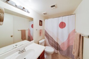 A bathroom with a white sink, a toilet, a shower curtain with abstract design, and a mirror above the sink. - Work + Relax Poolside! Nurse-Ready Glendale Rental (Glendale)