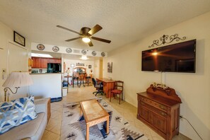 A living room with a sofa, a coffee table, a TV, and a ceiling fan. - Work + Relax Poolside! Nurse-Ready Glendale Rental (Glendale)