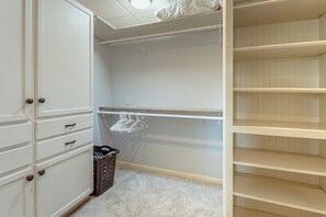 A walk-in closet with open shelving, a hanging rod, and a trash bin. - Wooded Extended Retreat: 15 Mi to Lake Lanier! (Cumming)