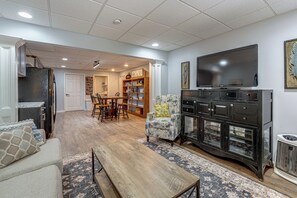 A spacious living room with a large flat-screen TV, a wooden coffee table, and a patterned rug. - Wooded Extended Retreat: 15 Mi to Lake Lanier! (Cumming)