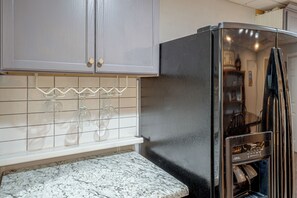 A kitchen with a stainless steel refrigerator, white tiled backsplash, and a marble countertop. - Wooded Extended Retreat: 15 Mi to Lake Lanier! (Cumming)