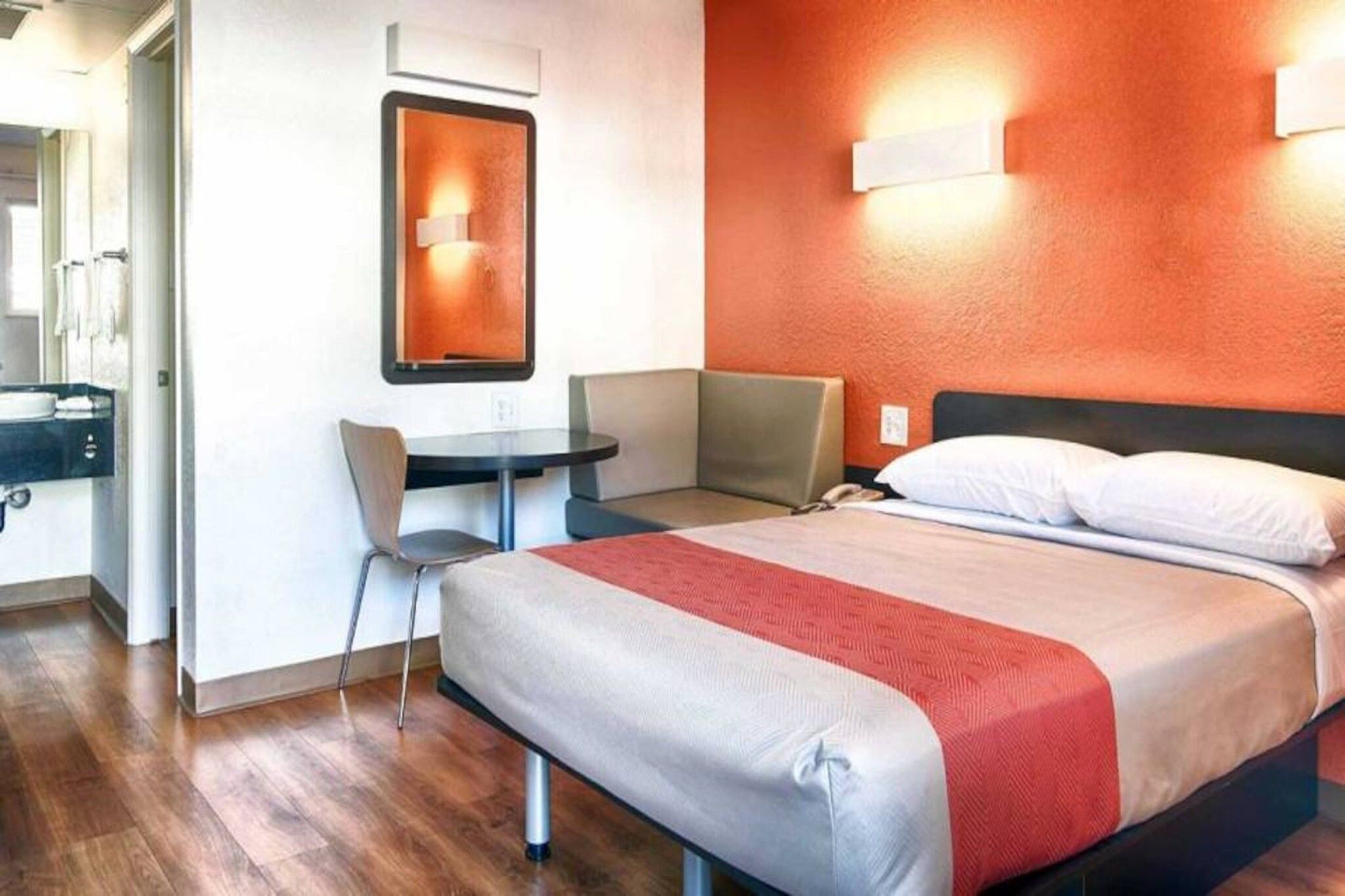 Una habitación de hotel con una cama, un escritorio y una silla.
