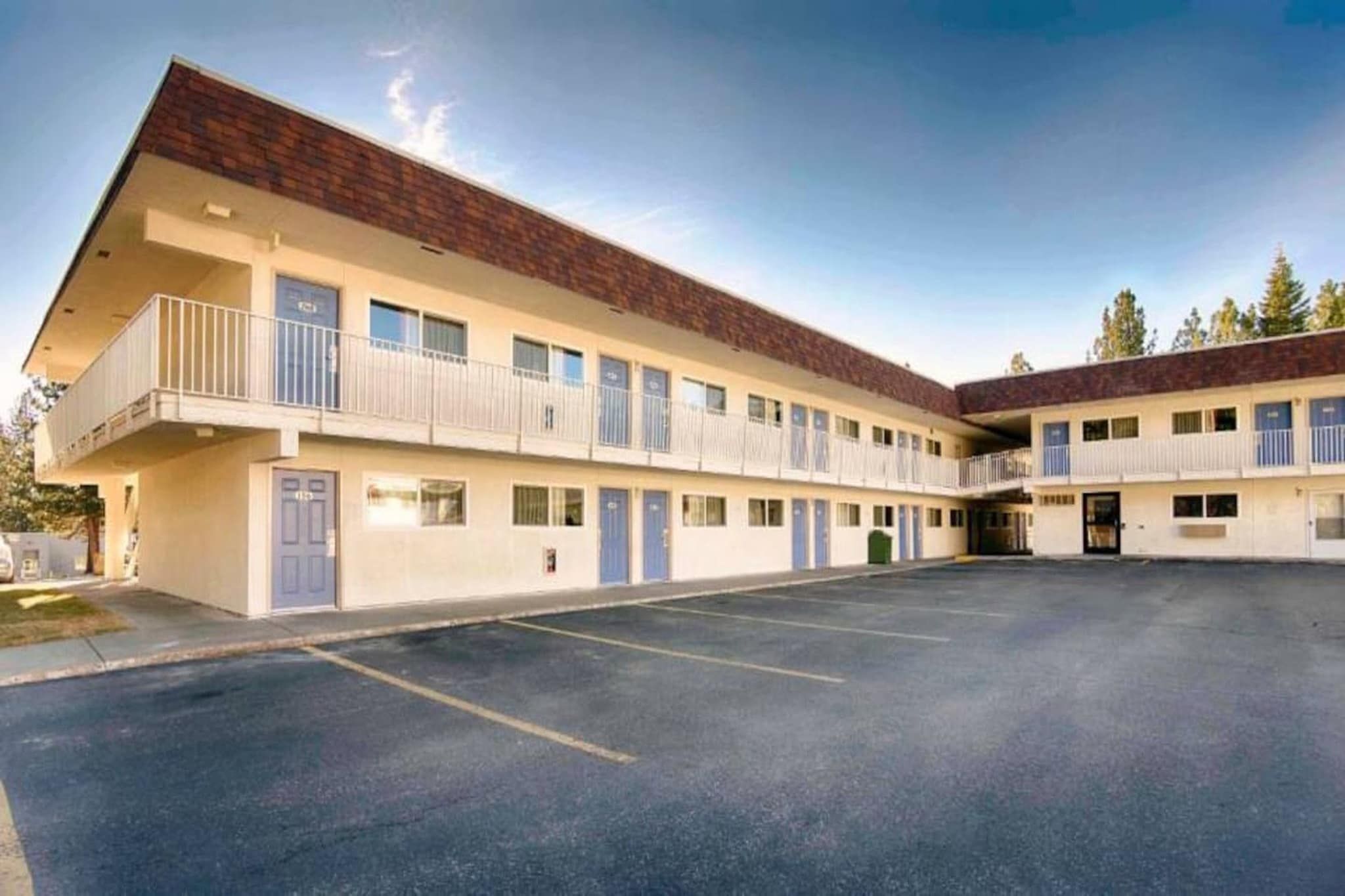A two-story motel with a parking lot in front.