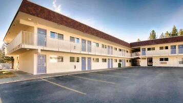 A two-story motel with a parking lot in front.