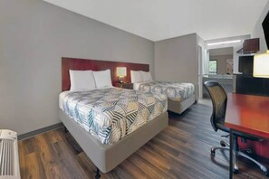 Una habitación de hotel con dos camas, un escritorio y una silla.