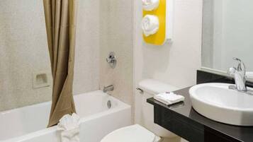 A bathroom with a bathtub, toilet, and sink.