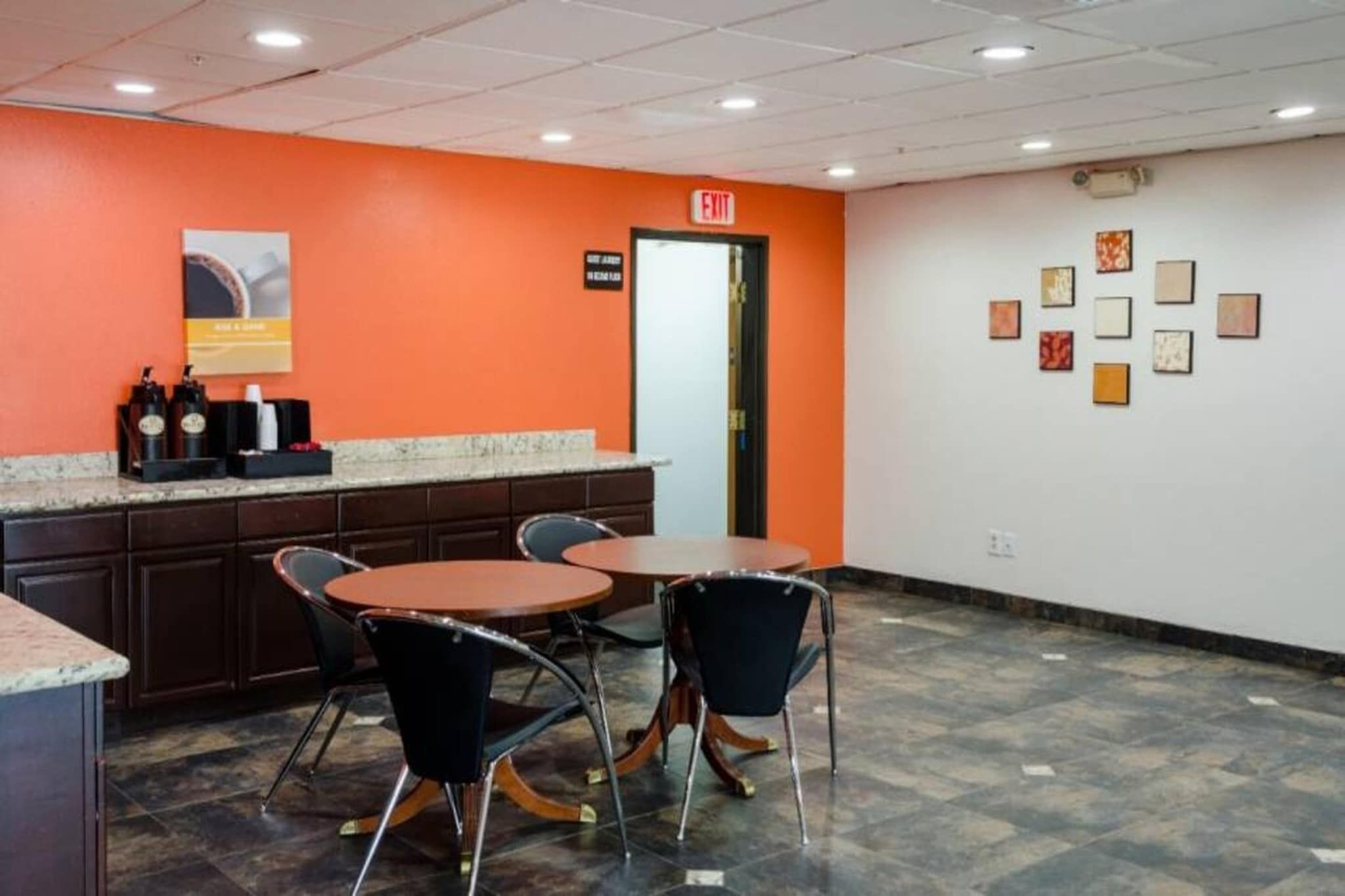 A conference room with a marble countertop, two round tables, and four chairs.