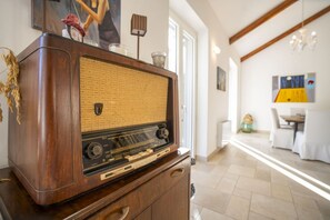 A vintage radio on a wooden cabinet in a well-lit room with a modern interior. - Capovillas - Country Villa Armonia with privat pool (zambrone)