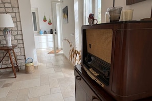 A room with a vintage radio, a lamp, and a stone wall. - Capovillas - Country Villa Armonia with privat pool (zambrone)