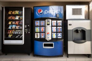 Ein Getränkeautomat mit Pepsi-Logo, einer gekühlten Auslage und einem Wasserspender.