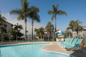 A swimming pool with lounge chairs and palm trees. - 1 Queen Bed | New 60s Retro-Style Decor (Santa Barbara)