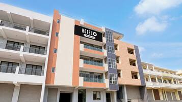 Un hotel de varios pisos con un letrero que indica que es administrado por OYO.