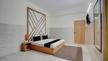 A modern bedroom with a wooden bed frame, a nightstand with a vase of flowers, and a wardrobe with a mirror.