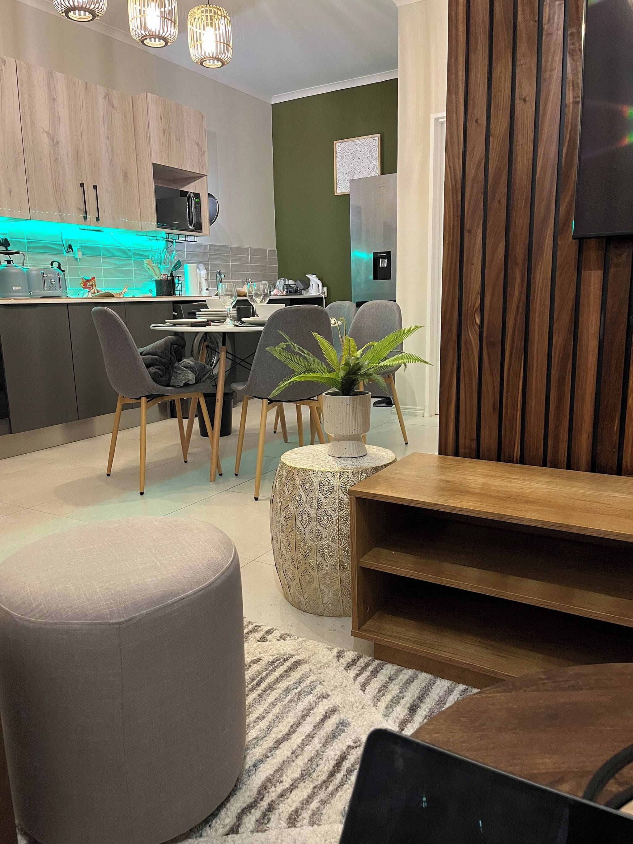 Una cocina moderna con comedor, un revestimiento de pared de madera y una planta en maceta.