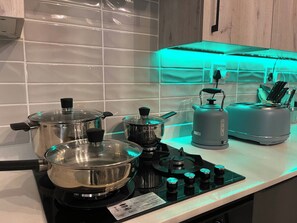 Eine Küche mit Gasherd, Töpfen, einem Wasserkocher und einem Toaster.