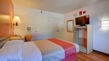 Une chambre d’hôtel équipée d’un lit, d’un bureau, d’une chaise, d’une télévision et d’une armoire.