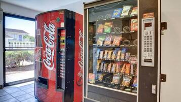 Een Coca-Cola automaat en een automaat voor snacks in een gebouw.