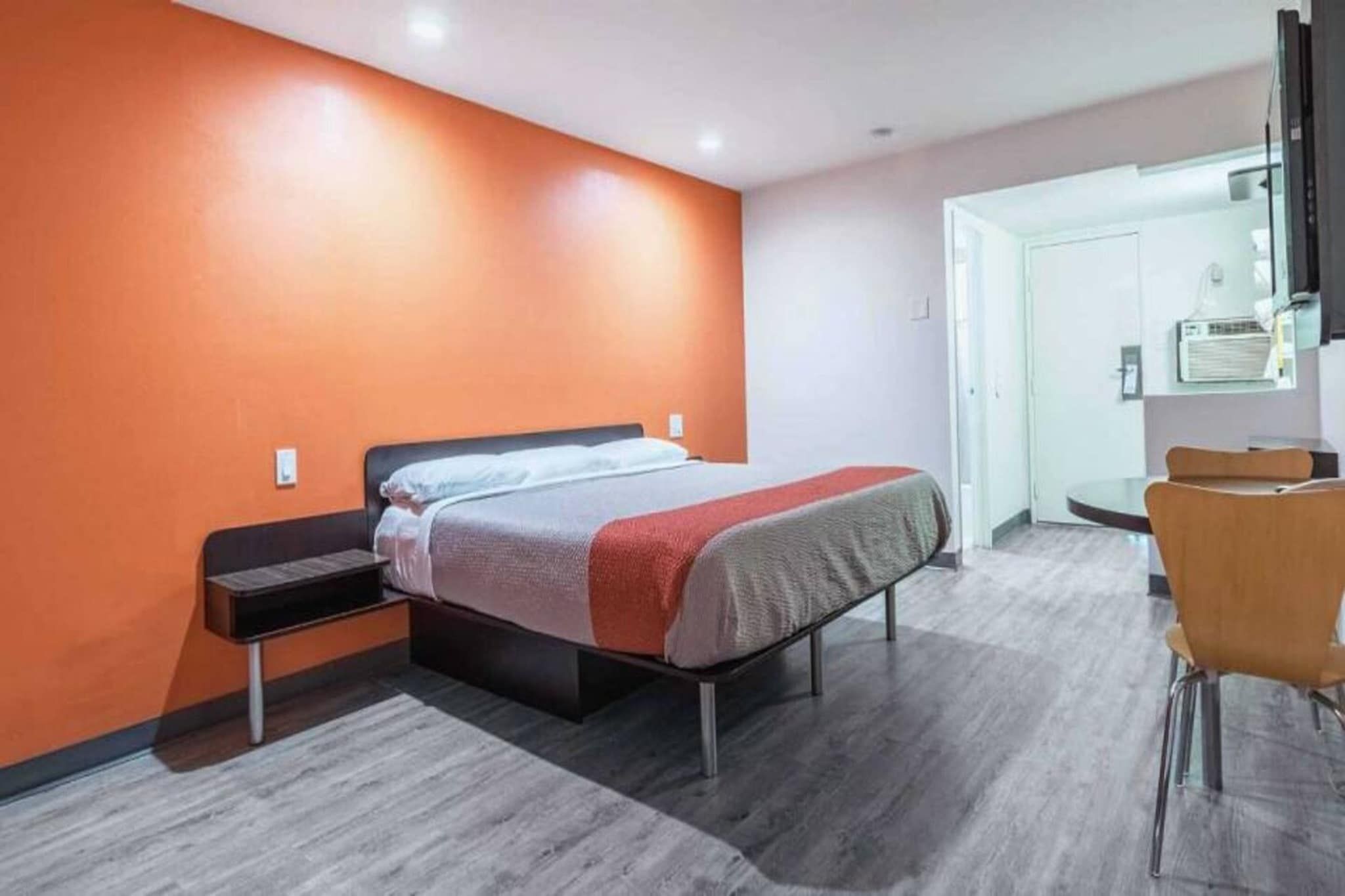 A hotel room with a bed, a desk, and a chair.