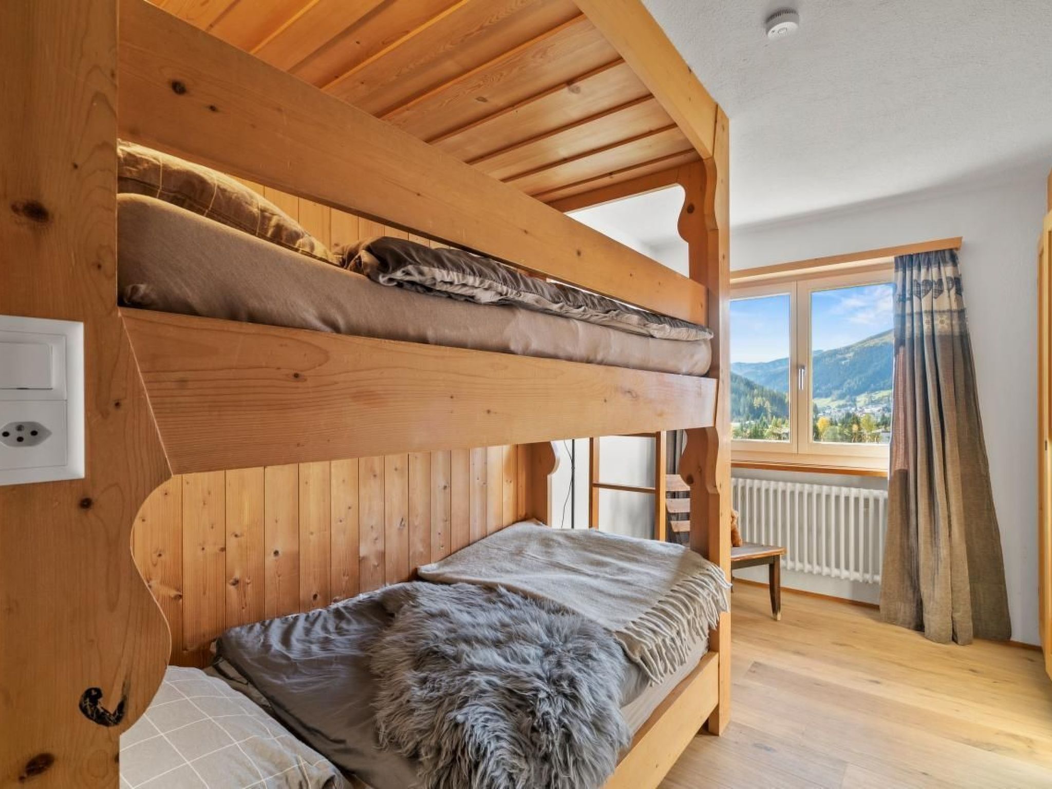 Une chambre avec des lits superposés donnant sur l’extérieur.
