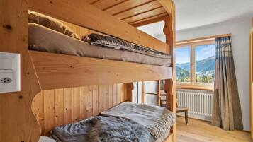 Une chambre avec des lits superposés donnant sur l’extérieur.