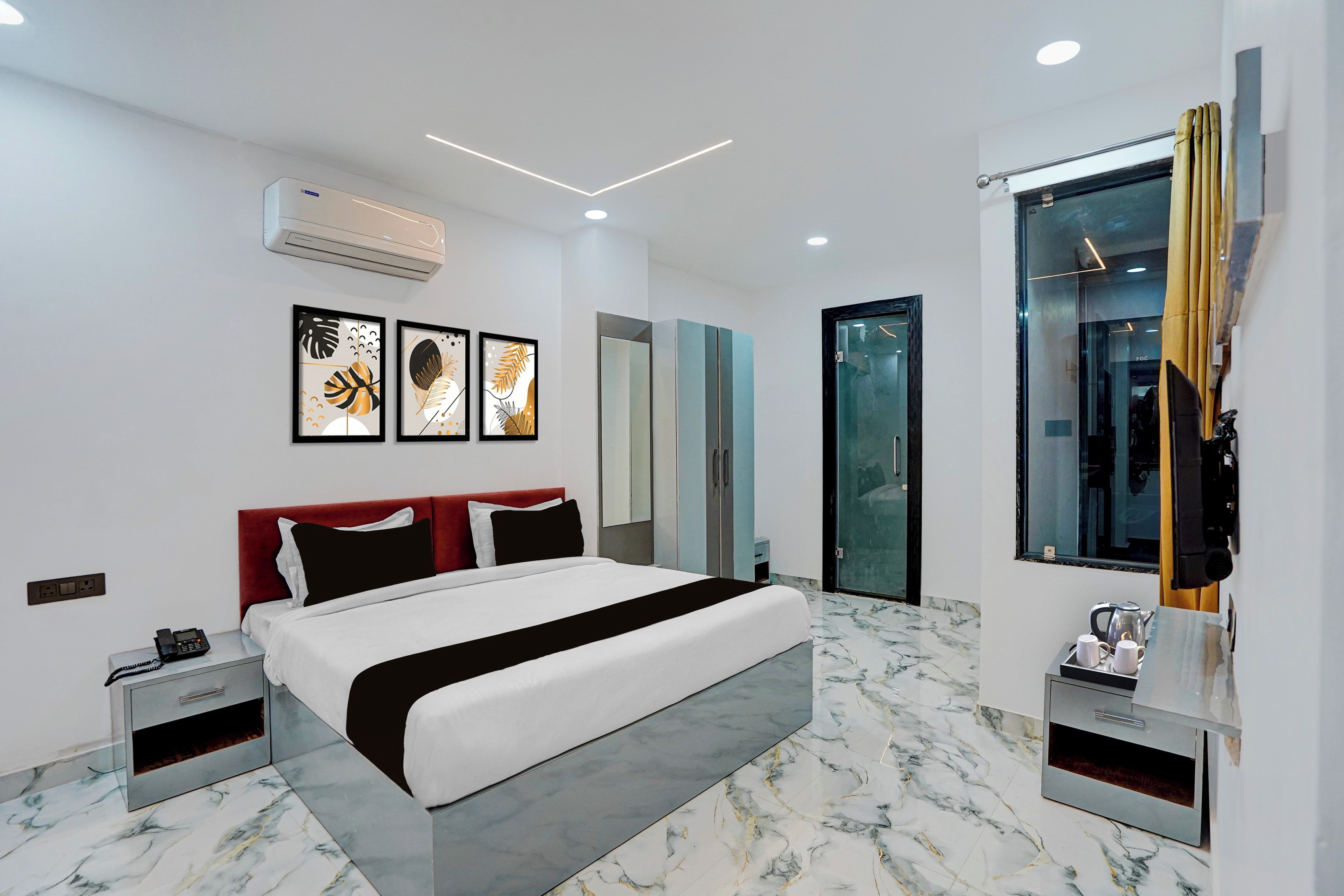 A modern bedroom with a bed, bedside tables, a wardrobe, and a bathroom with a glass door.
