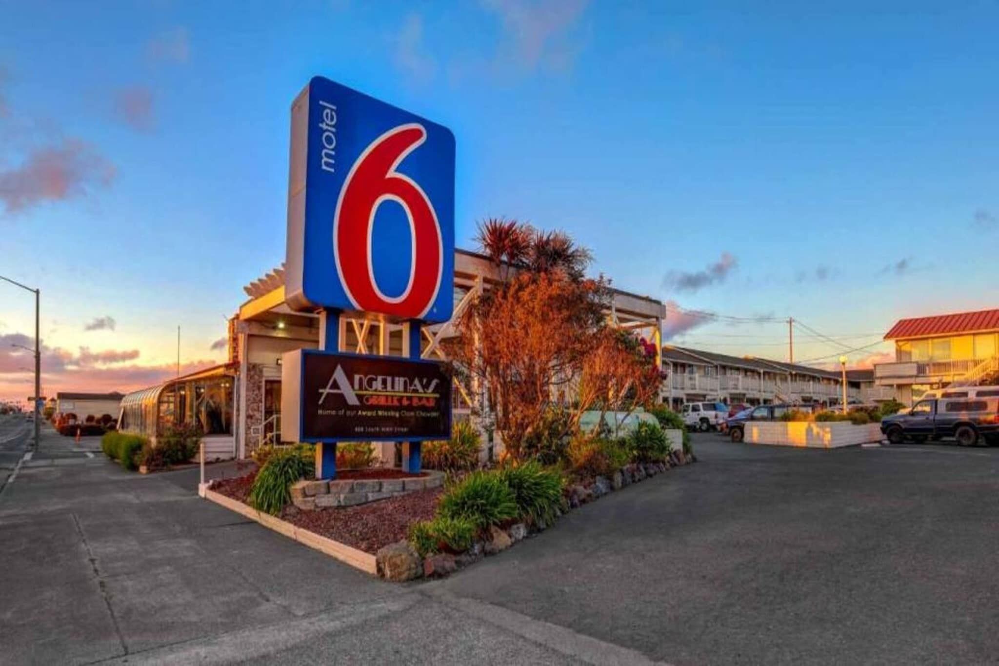 Ein Schild eines Motels mit der Nummer 6, ein Gebäude mit dem Schriftzug 'Angell's' und ein Parkplatz.