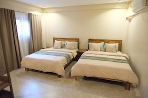 A hotel room with two single beds, a wooden headboard, a bedside table, and a window with curtains. - Frania Boutique Hotel (San Juan)