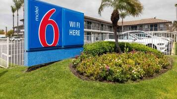 Une enseigne de motel avec le chiffre 6 et l’inscription « WiFi disponible », indiquant que le Wi-Fi est accessible.