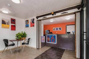 Un espace d’accueil comprenant un comptoir, une table et deux chaises.