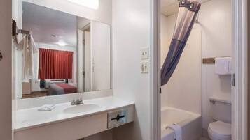 A bathroom with a white sink, mirror, and a shower curtain.