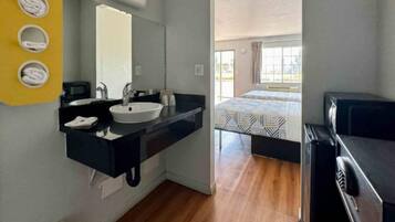 Ein modernes Badezimmer mit Waschbecken, Spiegel und Handtuchhalter.