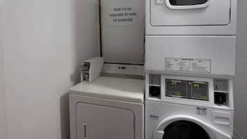 A laundry area with a sign stating 'Motel 6 is not responsible for items left unattended.'