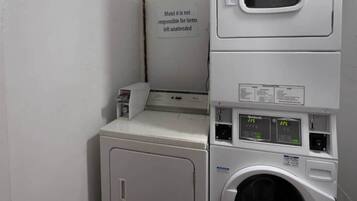 A laundry area with a sign stating 'Motel 6 is not responsible for items left unattended.'