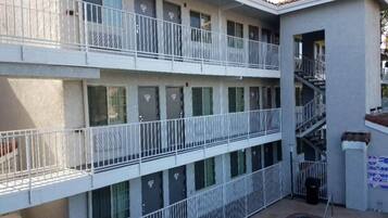 Un immeuble à plusieurs étages doté de balcons, d’une piscine et d’un escalier.