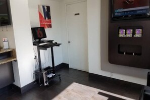 A reception area with a desk, a computer, a printer, a wall-mounted TV, and a vending machine. - 2 Queen Beds | Suite, Non-Smoking, Kitchen (Fairfield)