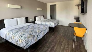 Ein Hotelzimmer mit zwei Betten, einem Schreibtisch und einem Sessel.