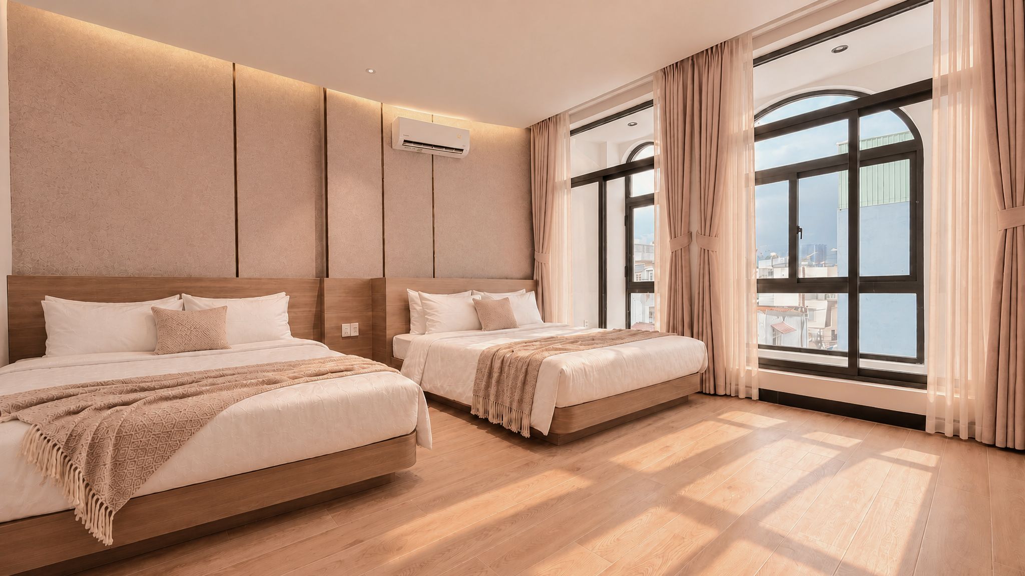 A hotel room with two beds, large windows, and a view of the city.